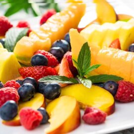 Sommerfrüchte auf hellem Teller – Symbol für Hautgesundheit im Somme